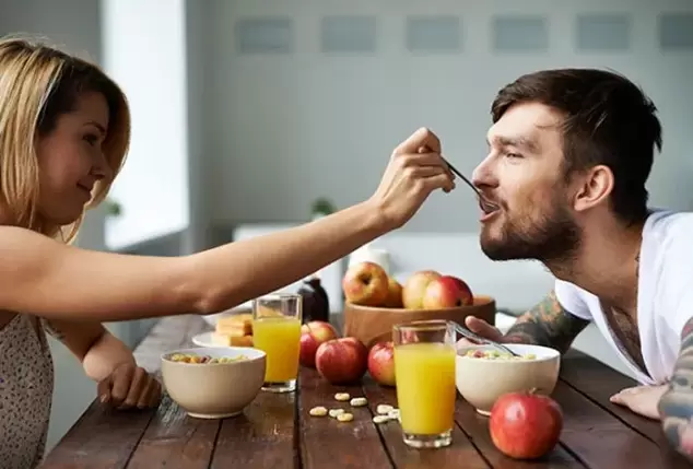 une femme nourrit un homme de noix pour augmenter sa puissance